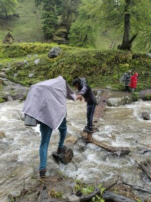 River Crossing in Rain over a Log Bridge.